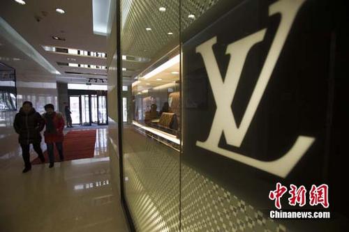 中国侨网资料图:民众从某知名奢侈品店经过。中新社记者 张云 摄