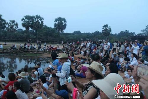 中国侨网资料图:国际游客守候在吴哥窟景区观看日出。 廖敏佳 摄