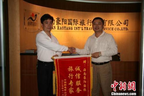 中国侨网图为客户向梁昌斌（右）赠送锦旗。豪阳国旅 供图
