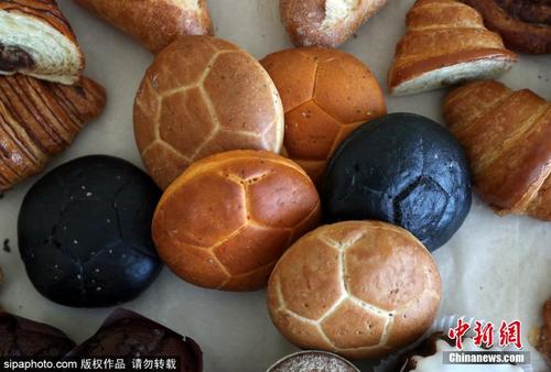 中国侨网资料图：俄罗斯莫斯科，当地面包店打造足球造型的面包，迎接2018世界杯到来。（图片来源：Sipaphoto））