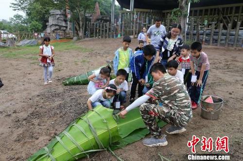 中国侨网图为饲养员与小朋友一起给非洲象包粽子。 韩璐 摄
