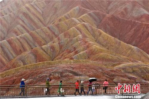 中国侨网进入7月以来，被称为“世界十大神奇地理奇观之一”的甘肃张掖丹霞地貌景观日均接待中外游客超过万人。　王将　摄
