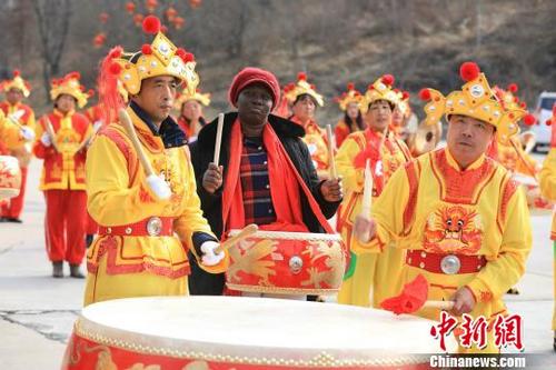 中国侨网1月28日,来自“一带一路”沿线几个国家的留学生组团来到山西王莽岭太行云顶体验中国年。图为外国留学生与村民们一起敲锣打鼓。 张为涛 摄