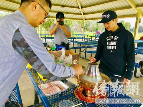 中国侨网北京青年千里迢迢背来可用于户外的紫铜火锅，打算在美国展开一场由火锅伴随的特别自助游。（美国侨报网/翁羽 摄）