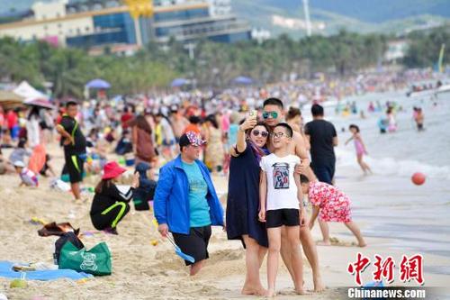 中国侨网图为在三亚海滨浴场旅游的游客。　骆云飞 摄