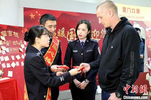 中国侨网澳大利亚旅客特拉维斯先生（右）成为厦门口岸144小时过境免签政策实施一年来第1000名旅客。供图