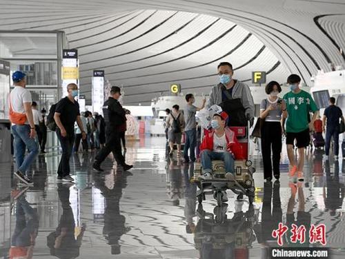 中国侨网6月3日,旅客在北京大兴国际机场出发层准备出行。自6月1日起,大兴机场国内航班开始逐步恢复。 中新社记者 侯宇 摄