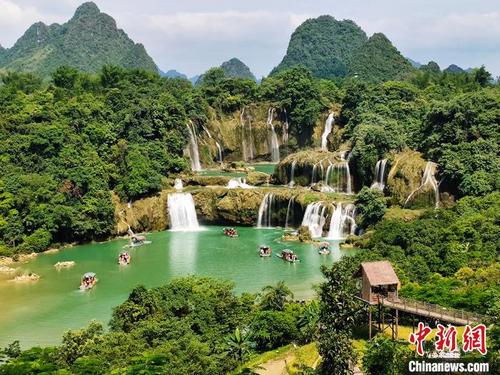 中国侨网图为游客在位于中越边境广西崇左市大新县境内的德天跨国瀑布景区乘船游览。 黄艳梅 摄