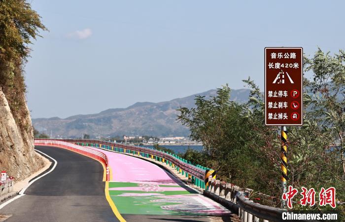 中国侨网10月5日，总长420米，有条“会唱歌”的“音乐公路”亮相辽宁省丹东市宽甸满族自治县长甸镇河口村下拉线--河口桃花岛对面。当驾驶车辆以45公里的时速驶过这段公路时，路面便会响起《在那桃花盛开的地方》的旋律。其原理是路面上的沟槽是根据不同乐曲的曲调设计切割的，不同的槽宽、槽间距和槽深象征着不同的音符，轮胎与地面的接触声音、与空气的撞击声音就变成有韵律的一个声音，“形象点说带槽的公路是’唱片’，汽车轮胎是‘唱针’，两者组合在一起，就像是留声机一样能‘唱歌’。图为“会唱歌”的“音乐公路”。中新社记者 于海洋 摄 
