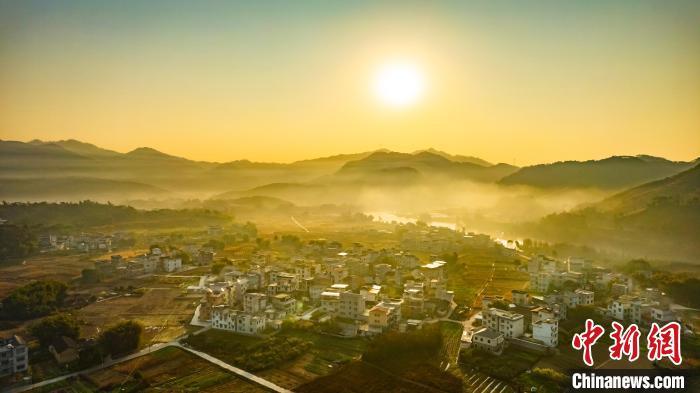 中国侨网1月4日,广西蒙山县西河镇水秀村,错落有致的民居与青山绿水相互映衬,在冬日晨光映衬下,若隐若现,宛如一幅水墨画卷,美不胜收。周火文 摄