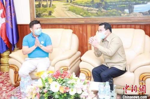 中国侨网柬埔寨江西总商会会长魏思钰（左）向柬埔寨官员介绍在柬赣商情况。　商会提供