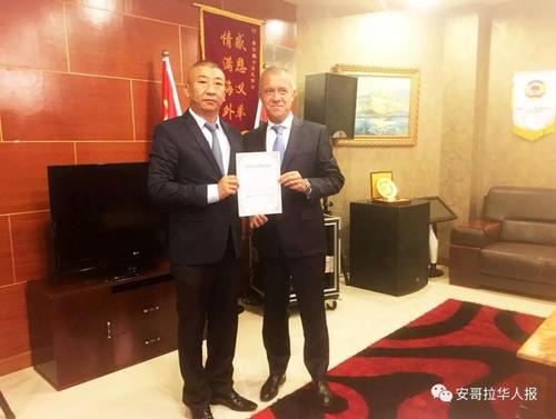 中国侨网安哥拉中国总商会长、华助中心负责人许宁(左一)向律师PEDRO(右一)颁发聘书。(安哥拉华人报微信公众号)