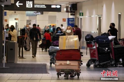 中国侨网当地时间9月7日，加拿大多伦多皮尔逊国际机场，刚入境的国际旅客准备走出航站楼。 中新社记者 余瑞冬 摄