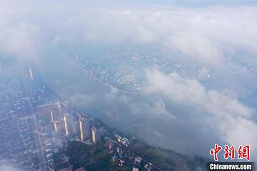 中国侨网融江和城市楼宇在云雾中若隐若现。　谭凯兴　摄