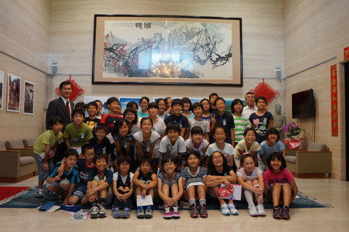 李文亮（后排左一）与日本小学生合影。（日本新华侨报网）