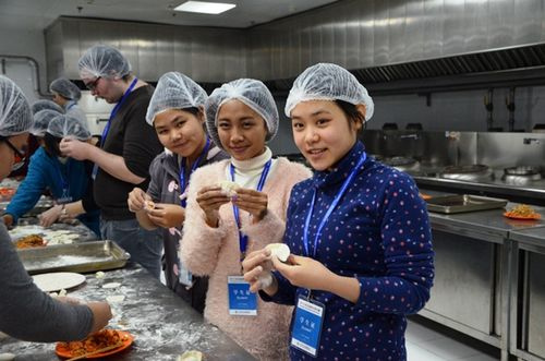 图为营员们学习包饺子。