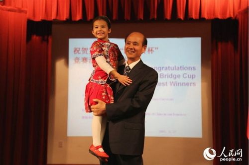 中国侨网中国驻旧金山总领馆举办招待会,庆祝第十一届“汉语桥杯”比赛圆满成功。中国驻旧金山总领事罗林泉(右)将获得中文诗歌朗诵1-2年级普通话非母语组冠军美喜卓安(左) 抱起。(人民网 韩莎莎摄)