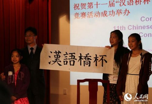 中国侨网获得9-12年级毛笔书法亚军的欧纪莹在招待会上进行书法表演。(人民网 韩莎莎摄)