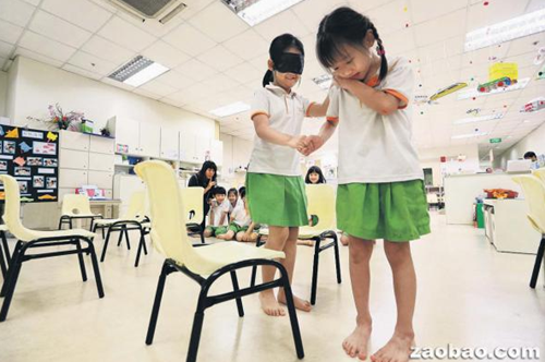 中国侨网职总优儿学府推出以华语授课的品格教育课程,儿童在相关的游戏中,协助“看不到”的朋友越过障碍安全行走,从中培养负责任和关怀的价值观。(新加坡《联合早报》/何家俊 摄)
