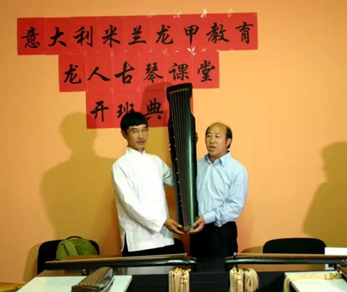 中国侨网授琴仪式。左起:谢建东、李群来 (欧洲《华人街》)