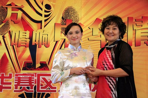 中国侨网评委王颖老师为Akela颁发精美冠军奖杯。(丁玎 摄)