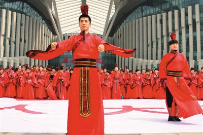 7月28日，山东泰安泰山千古情剧院门口广场，数千名来自全球各地的华人，身穿大红汉服，向天地、祖先鞠躬行拜谒礼，祈福国泰民安。（魏炜