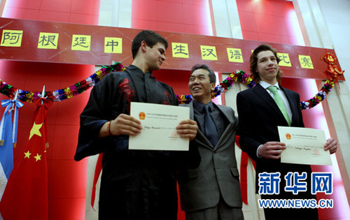 图为中国驻阿根廷使馆文化参赞韩孟堂（中）为一等奖获得者费利佩·梅洛维奇（左一）和校友圣地亚哥·布卡略（右一）颁发证书。