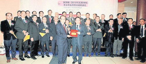 刘利民(右)代表董总,从主持监誓的会务顾问胡万铎手中接过宣誓书。