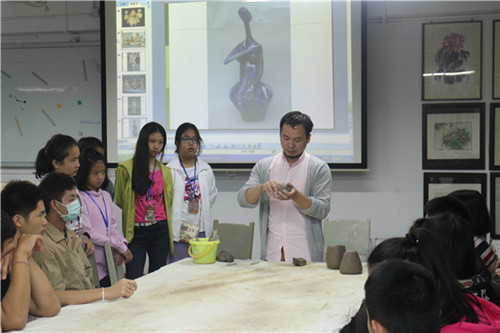 戴连和老师向学生展示陶艺揉捏方法