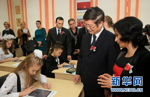 校长帕修克维奇女士（右一）向中国大使崔启明（右二）介绍学生使用新设备学汉语的情况。新华社记者陈俊锋