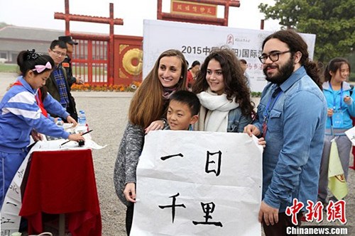 一名一年级小学生将自己书写的书法作品“一日千里”赠与法国朋友。