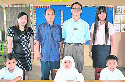新邦木阁华小3名新生与邱峋华(右二起)、吴始发、级任教师赖莉芳合照;右一为郑玉妹。(马来西亚《星洲日报》)