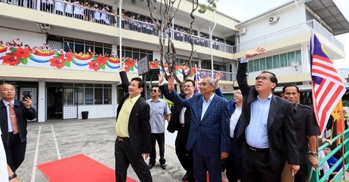 小学生们挥着国旗和州旗热烈欢迎首长阿迪南的莅临,首长更开心的与学生们挥手示意。
