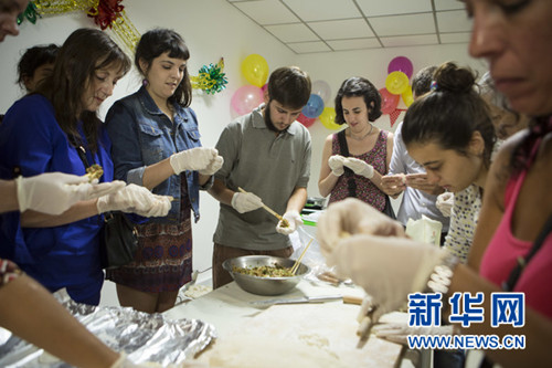 参加联谊会的阿根廷留华校友在一起学包饺子。新华网发（马丁·萨巴拉摄）