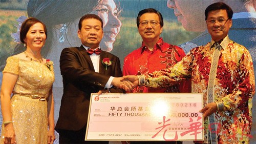 方天兴(右)在廖中莱(右2)见证下,从蔡兆生与林淑英夫妇手中接过捐献华总大厦基金模拟支票。