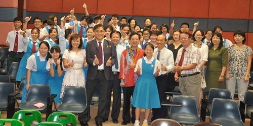 从事教职30多年的黄惠康,乐于和学生打成一片,并与学生合照留念。