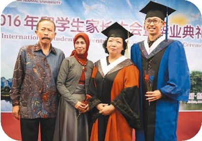 6月23日,参加广西师范大学毕业典礼的留学生及家长与广西师范大学党委书记王枬(右二)合影。中新社记者