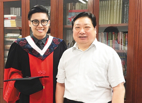 图为世玉(左)和北京语言大学党委书记、博士生导师李宇明合影。