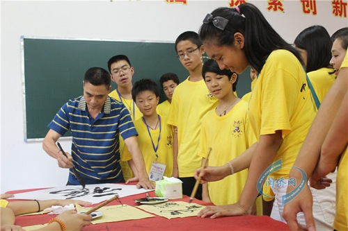 营员围在老师身旁，学习书法。