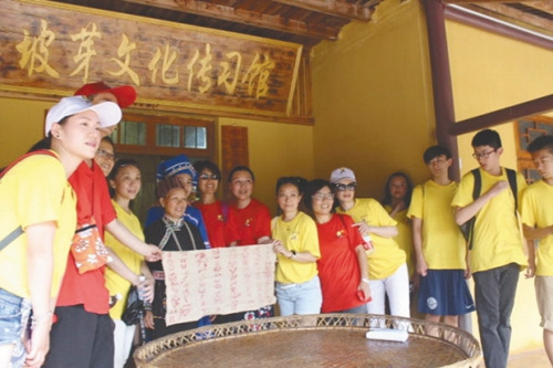 图为华裔青少年一行在坡芽文化传习馆前开展文化交流活动。(卢雪丽