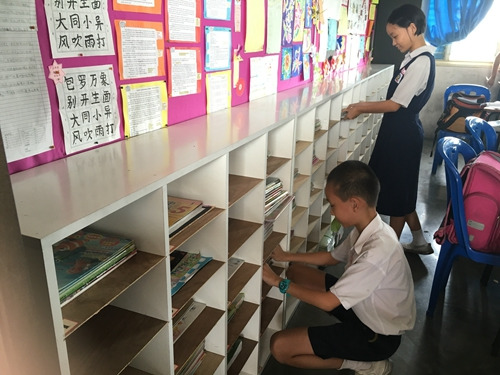 学生利用书架，培养收拾书包的习惯。（马来西亚《星洲日报》）