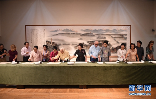 9月5日,国家主席习近平夫人彭丽媛邀请出席二十国集团领导人杭州峰会外方代表团团长夫人参观中国美术学院。这是彭丽媛与来宾一同书写汉字“和”。(新华社记者