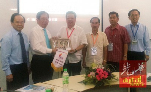 刘利民（左2）赠纪念品给华联中学。（马来西亚《光华日报》）