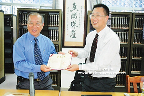 韩山元先生（左）接受海南大学图书馆颁发的捐赠证书