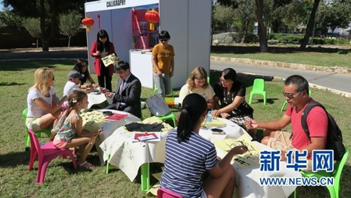 王振先院长带领孔院全体教师指导汉语爱好者练习书法。新华网发