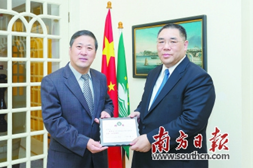 崔世安(右)从暨大校长胡军手中接过国务院侨办签发的聘书,担任暨大董事会副董事长。