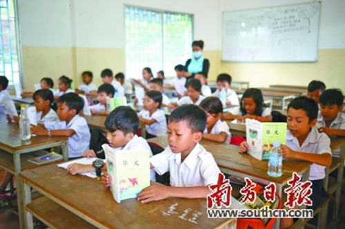在柬埔寨公立启华学校，孩子们上华文课读汉语课本。