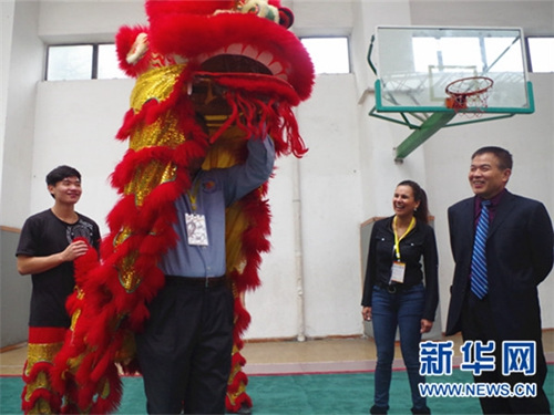 美国校长现场体验舞狮。新华网发(石薇摄)