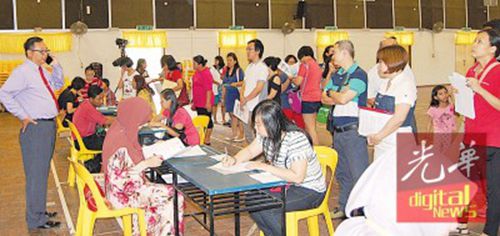 中国侨网吉华国中二校家长为新生办理入学手续。(马来西亚《光华日报》)