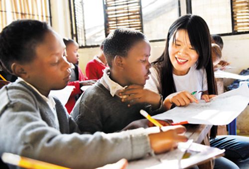 中国侨网图为2016年8月2日,在位于肯尼亚首都内罗毕的长青造梦小学,“造梦”公益组织志愿者陈舒捷(右一)在给孩子们上课。 新华社记者 李百顺摄